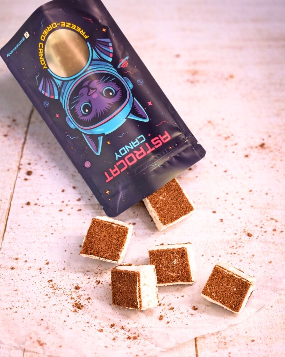 Gefriergetrocknete Astroschnitten von Astrocat Candy in Vorderansicht mit geöffneter Tüte und sichtbarem Inhalt