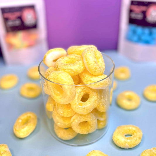 Gefriergetrocknete Bananenringe (Halal) in einem Glasbehälter mit heller gelblicher Färbung – Astrocat Candy Produktdarstellung.