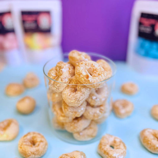 Gefriergetrocknete Colaringe (Halal) in einem transparenten Glasbehälter – farbenfrohe Ringe sichtbar, Produkt von Astrocat Candy.