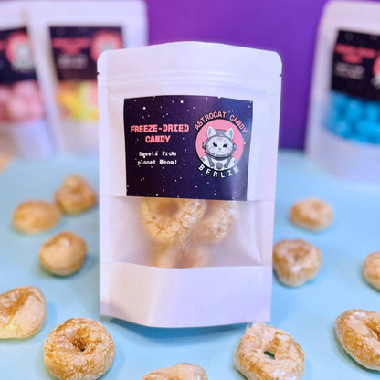 Gefriergetrocknete Colaringe (Halal) in einem weißen Kraftpapier-Mylarbeutel – Produktvorderseite von Astrocat Candy vor neutralem Hintergrund.