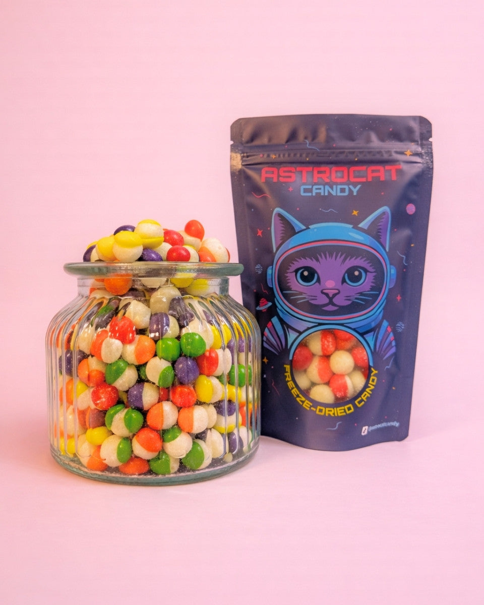 Gefriergetrocknete Rainbow Bites in der Vorderansicht im Glas mit stehender Tüte, bunt, knusprig und hochwertig als Produktfoto dargestellt.