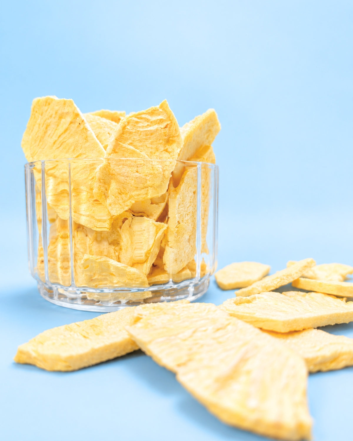Knusprige gefriergetrocknete Ananasscheiben im Glas mit frischer Ananas