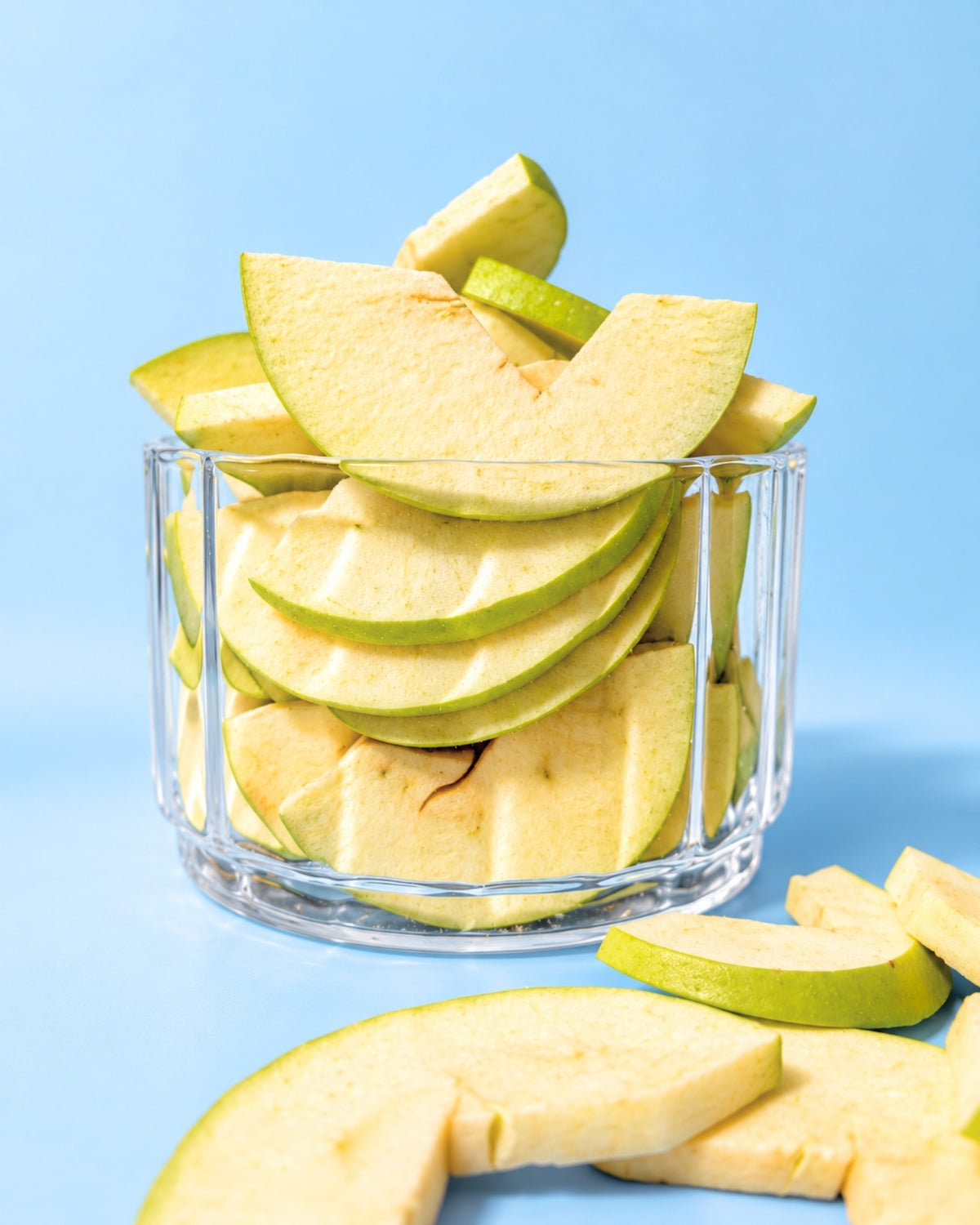 Gefriergetrocknete saure Apfelscheiben im Glas mit frischem Apfel