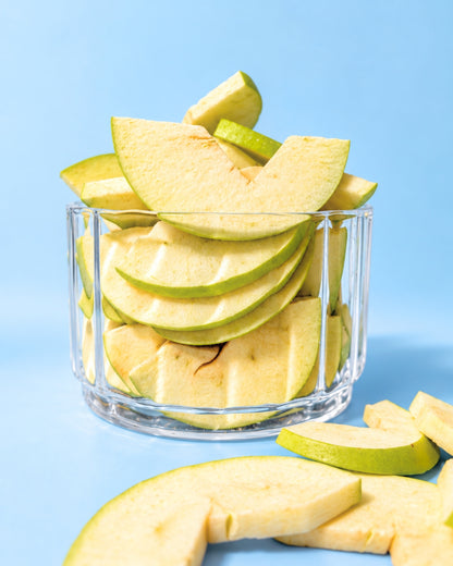 Gefriergetrocknete saure Apfelscheiben im Glas mit frischem Apfel