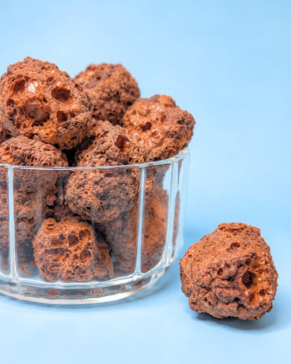 Nahaufnahme von gefriergetrockneten Schoko Stückchen im Glas mit Schoko Stücken auf dem Tisch