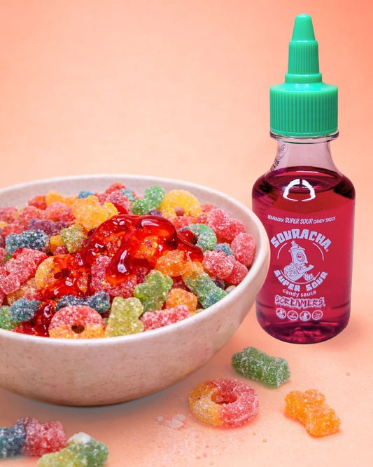 Schüssel mit bunten Süßigkeiten und Souracha Super Sour Candy Sauce, daneben steht die Flasche.